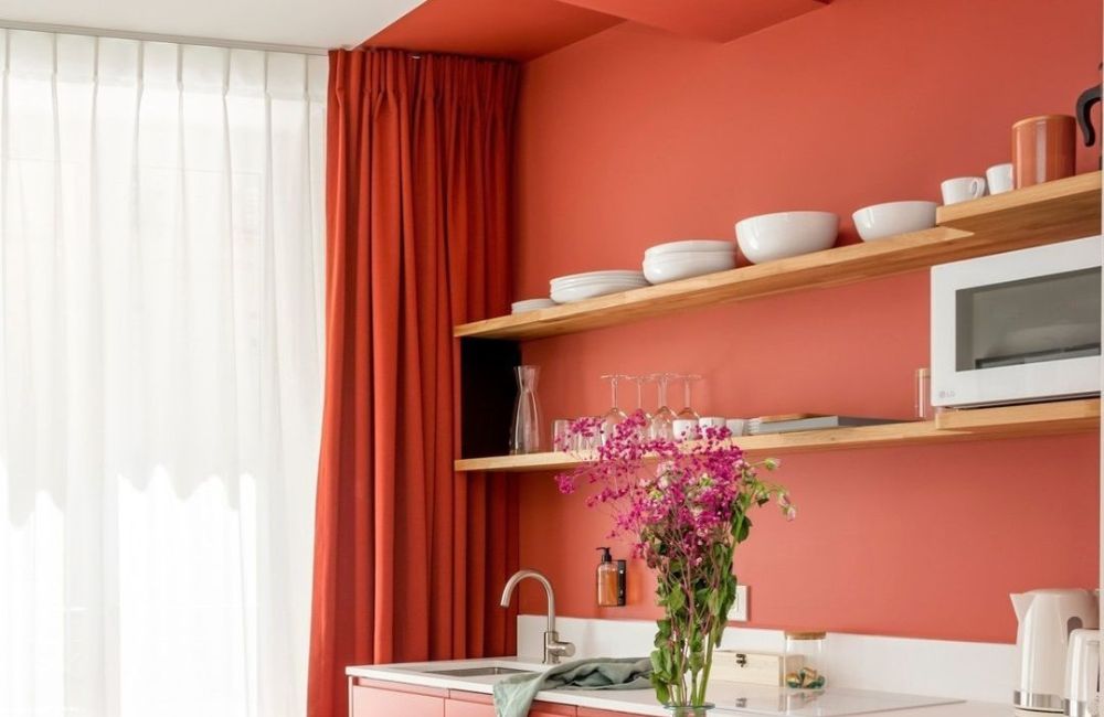 Bianco e rosso, grazie ai due colori, la stanza guadagna una cucina separata